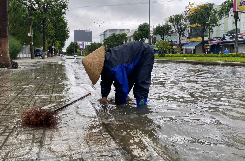 Công nhân khơi thông cống rãnh để nước thoát nhanh, không để tình trạng ngập sâu kéo dài ở các tuyến phố.