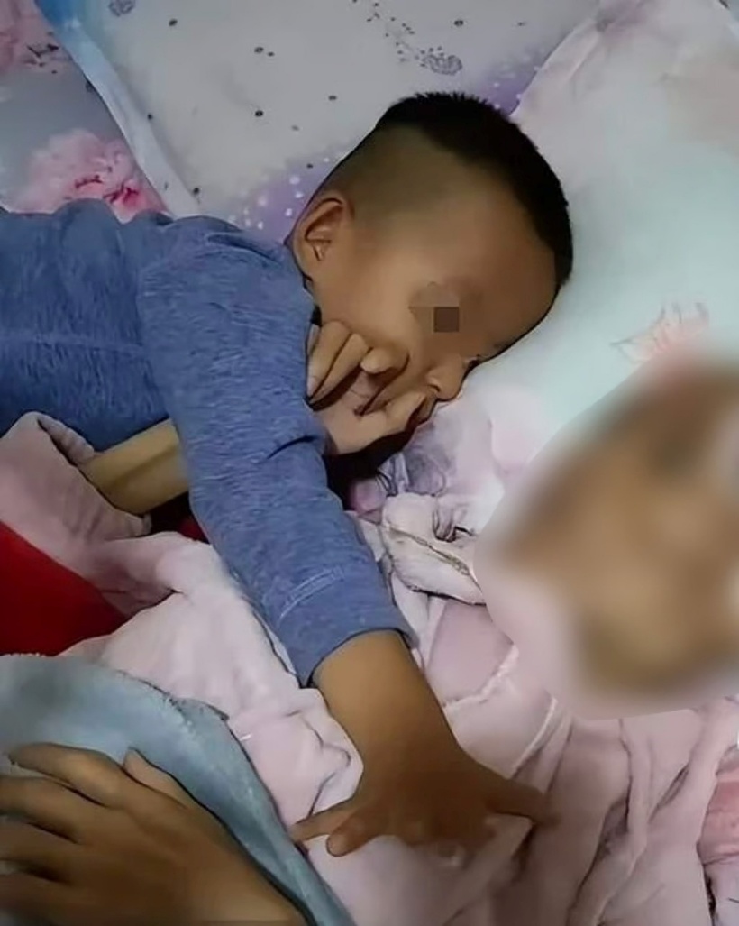 Cậu bé Yang Yucheng nằm cạnh mẹ, ngây thơ hỏi tại sao mẹ không nói chuyện với mình. Ảnh: Douyin