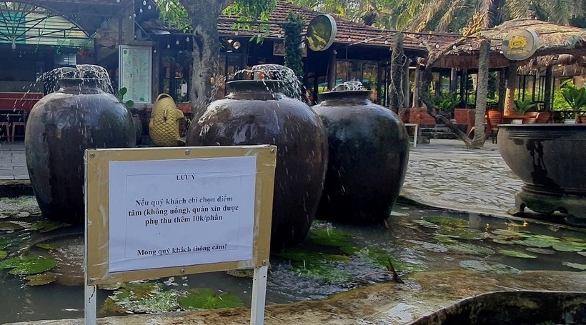 Quán ăn sáng cà phê Trà Sen Cọ Dầu đã gắn thêm biển thông báo trước lối vào về việc sẽ phụ thu 10.000 đồng/khách nếu "ăn không uống" - Ảnh: Tuổi Trẻ TP.