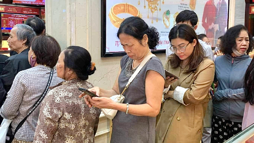 Khách hàng liên tục xem điện thoại, theo dõi và cập nhật giá vàng. Ảnh: Vietnamnet