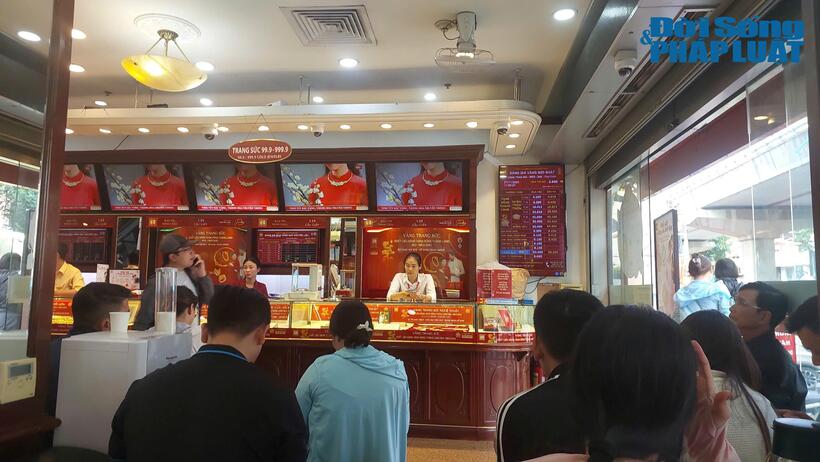 Trưa ngày 7/11, người dân xếp hàng chờ đến lượt giao dịch vàng tại cửa hàng Bảo Tín Minh Châu cơ sở Cầu Giấy, Hà Nội.