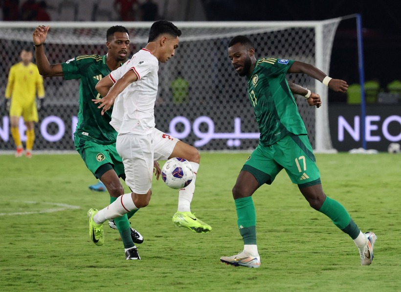 Marselino Ferdinan (áo trắng) tả xung hữu đột giữa vòng vây của hai cái bóng áo xanh Saudi Arabia . Ảnh: Reuters