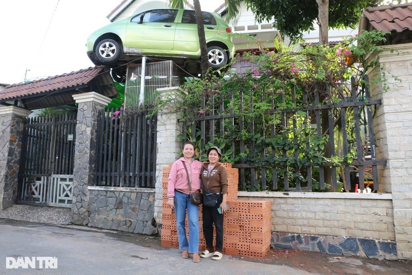 Chiếc ô tô nằm "vắt vẻo" trên mái cổng một ngôi nhà ở Đồng Nai. Ảnh: Dân trí