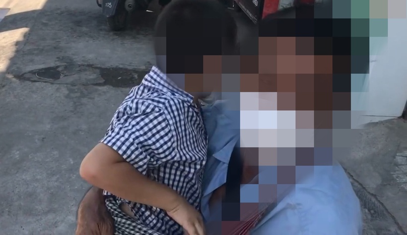Ông Q. bế con trai út ra đường xin tiền. Ảnh: Nhịp sống Việt