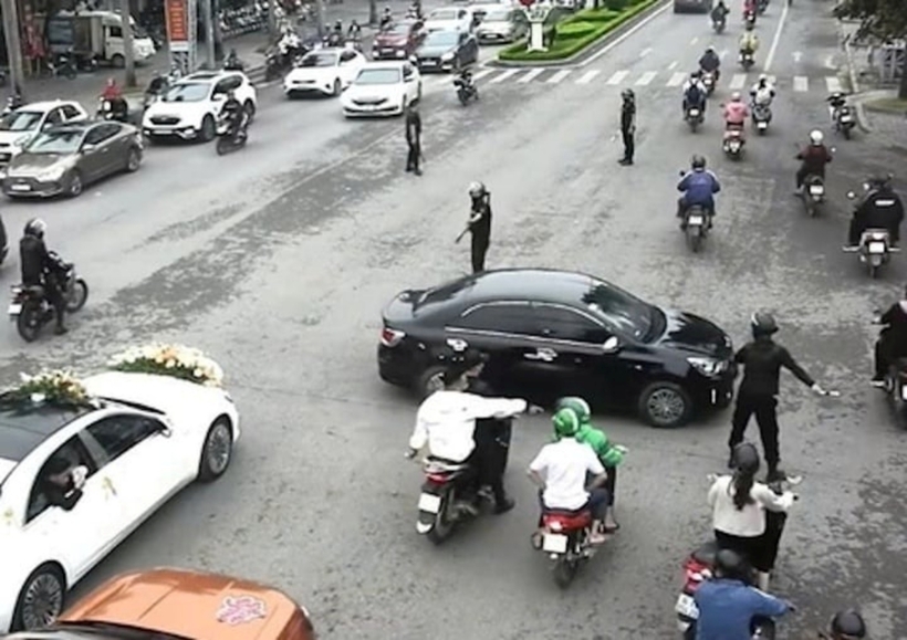 Nhóm "vệ sĩ" chặn các phương tiện giao thông trên đại lộ Lê Lợi (TP.Thanh Hóa, tỉnh Thanh Hóa) để cho đoàn xe đám cưới đi qua. Ảnh: VTC News