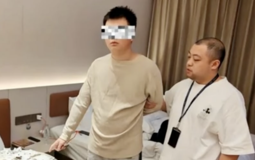 Nam thanh niên bị bắt khi đang dùng chiêu "bẩn" để tống tiền một khách sạn. Ảnh: SCMP