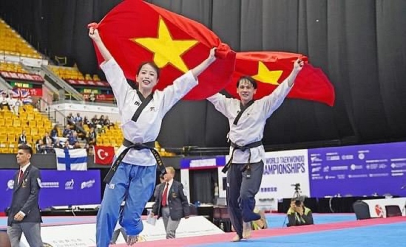 Châu Tuyết Vân cùng Nguyễn Thiên Phụng nâng cao lá cờ Việt Nam ăn mừng thành tích giành huy chương vàng. Ảnh: Tuổi Trẻ