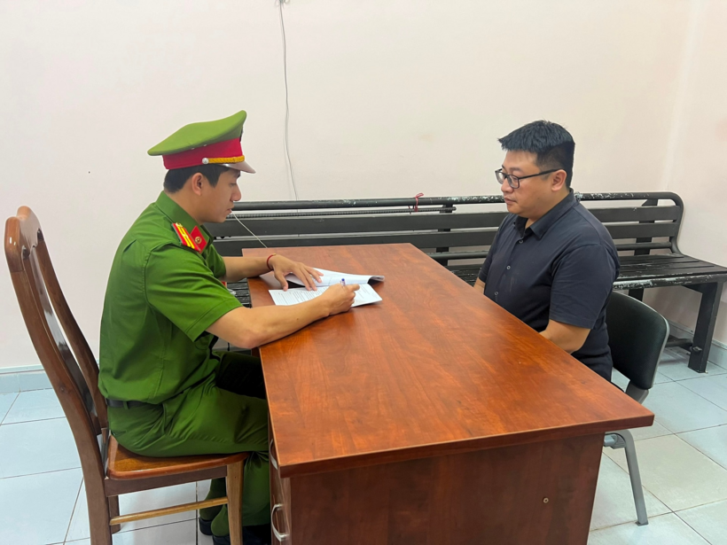 Cán bộ điều tra lấy lời khai Nguyễn Gia Lộc. Ảnh: Hà Nội Mới