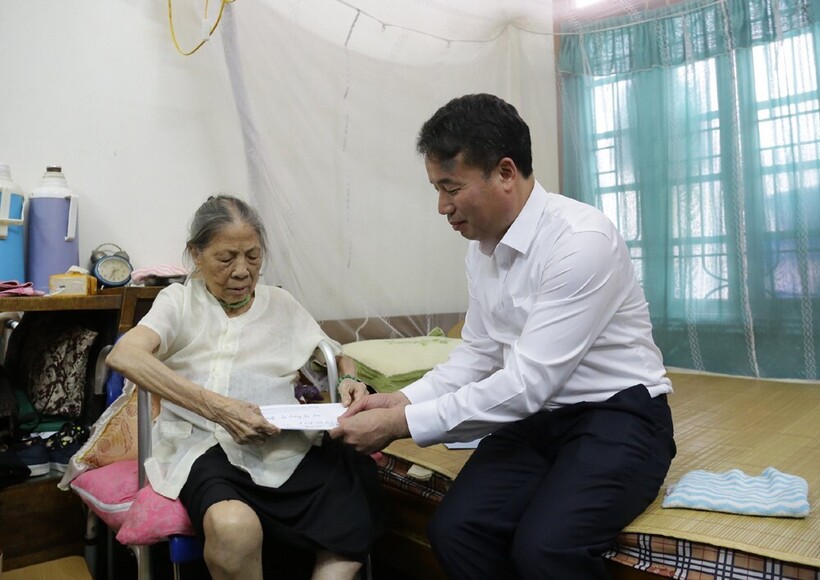 Ông Nguyễn Thế Mạnh - Tổng Giám đốc BHXH Việt Nam thăm hỏi, trao lương hưu tại nhà cho bà Lương Thị Hai