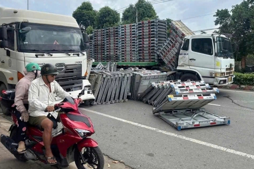 Hiện trường vụ hàng chục tấm pallet sắt trên xe đầu kéo bị đứt xích, rơi xuống đường. Ảnh: Dân Trí