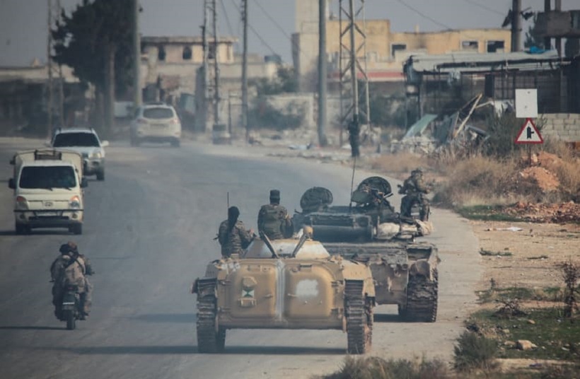 Phiến quân do nhóm Hồi giáo Hayat Tahrir al-Sham cầm đầu lái xe dọc theo một con phố ở al-Rashideen, tỉnh Aleppo, Syria. Ảnh: Reuters