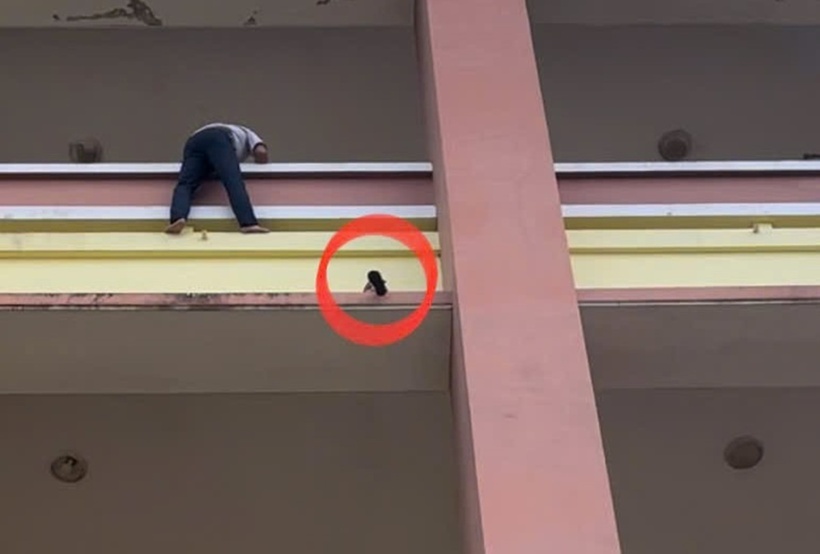 Thót tim cảnh chiến sĩ công an giải cứu bé gái 3 tuổi chênh vênh ở tầng 4. Ảnh: Báo CAND.