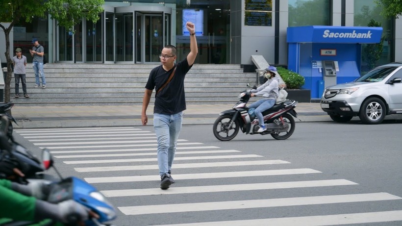 Trường hợp không có đèn tín hiệu, vạch kẻ đường, cầu vượt, hầm dành cho người đi bộ thì phải quan sát và khi qua đường phải có tín hiệu bằng tay. Ảnh minh họa