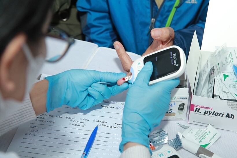 Cán bộ y tế lấy máu để tầm soát vi khuẩn HP cho người dân. (Ảnh Hiền Trinh)
