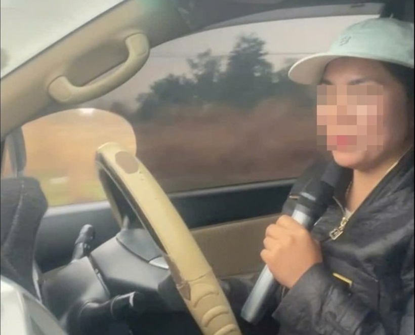 Nữ tài xế vừa lái xe vừa cầm mic hát karaoke. Ảnh: Tiền Phong