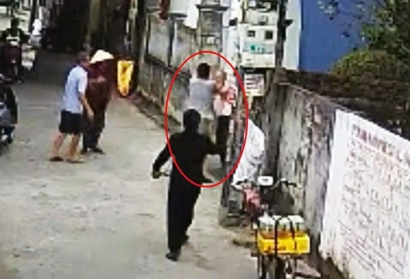 Dù được hàng xóm can ngăn, kéo ra đường nhưng sau đó Vũ Ngọc Thịnh tiếp tục lao vào đánh ông L. ngay tại cổng. Ảnh: Báo Người lao động.