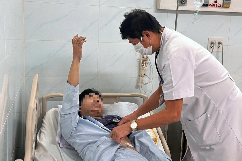 Bác sĩ thăm khám cho anh N.C., nạn nhân trong vụ cháy nhà ở Tân Bình làm 2 người chết, nhiều người bị thương. (Ảnh: Tuổi trẻ)