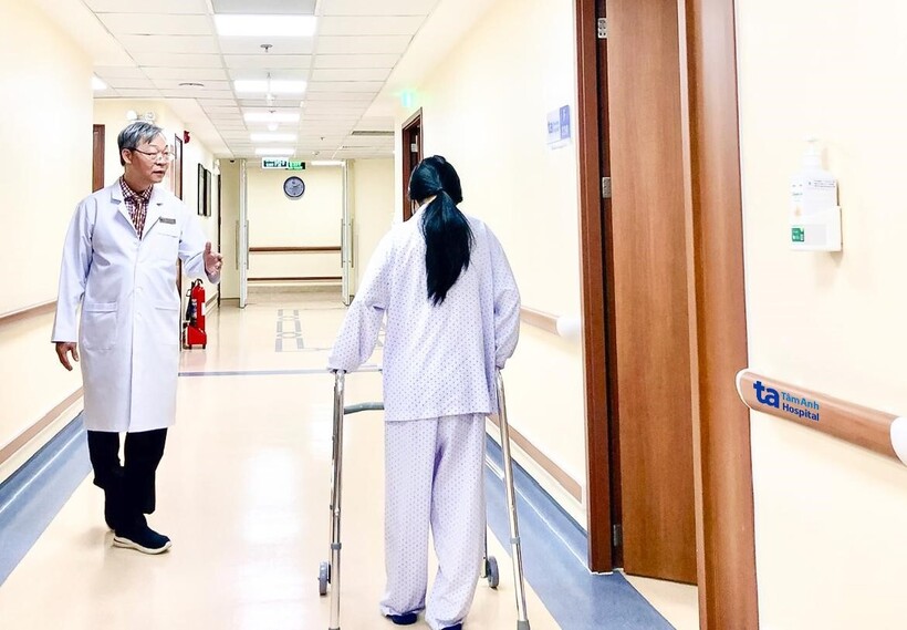 Bệnh nhân 15 tuổi tập đi dưới sự hướng dẫn của bác sĩ Tấn Sĩ sau một ca mổ u tủy sống bằng Robot AI. Ảnh: Bệnh viện Đa khoa Tâm Anh TP.HCM