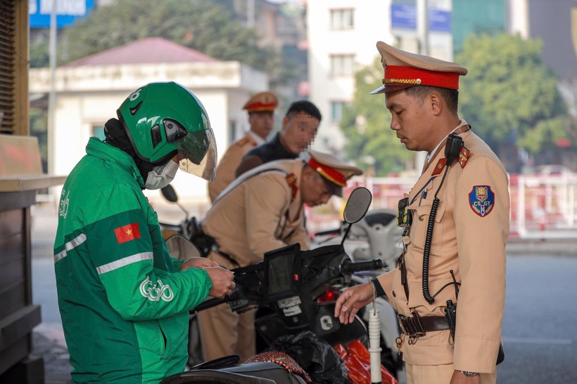 Tài xế xe ôm công nghệ tên là N.T.A (quê Thái Bình) trình bày đang vội giao đơn hàng ship cho khách nên cố tăng ga vượt lên khi đèn đỏ.