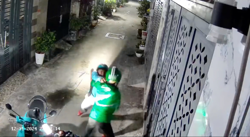 Camera nhà dân ghi lại người đàn ông (trái) chặn xe đánh, ném pháo về tài xế xe công nghệ. Ảnh: Báo Thanh Niên