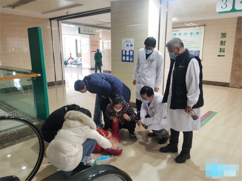Các bác sĩ phối hợp để cứu cụ bà bị ngất xỉu. Ảnh: Xinpai News