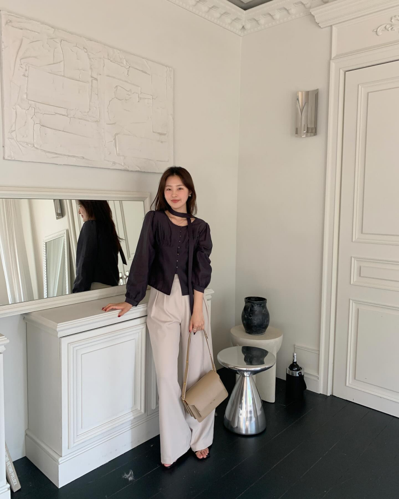 Áo blouse tay bồng, mang tông màu tối có sự sang trọng, quý phái. Chị em nên kết hợp mẫu áo này với quần âu sáng màu để vẻ ngoài trở nên trẻ trung, không bị cộng tuổi.