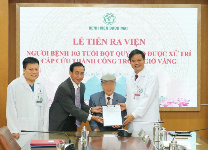 PGS.TS Đào Xuân Cơ - Giám đốc Bệnh viện Bạch Mai chúc mừng gia đình và trao giấy xuất viện cho cụ D.. Ảnh: Sức Khỏe & Đời Sống