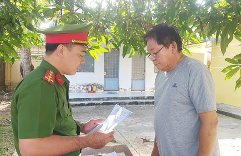 Công an tống đạt quyết định khởi tố, bắt giam Trần Văn Bé. Ảnh: VietNamNet
