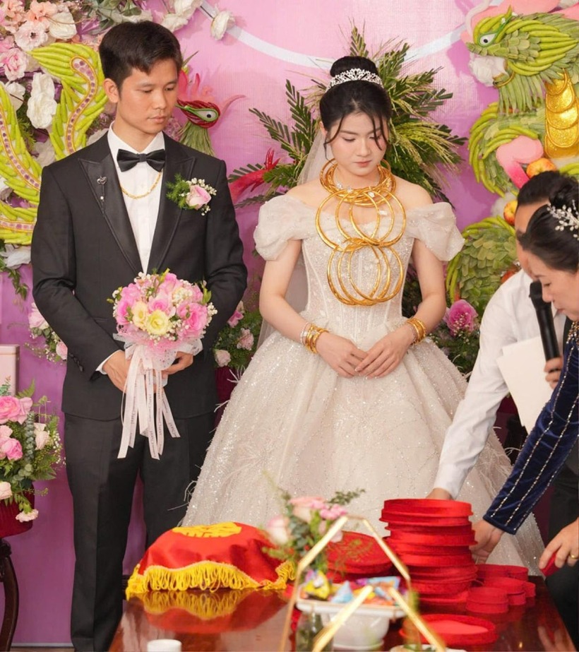 Do số vàng quá nhiều, một số người thân phải hỗ trợ lồng kiềng vàng vào nhau để đeo trên cổ cô dâu.
