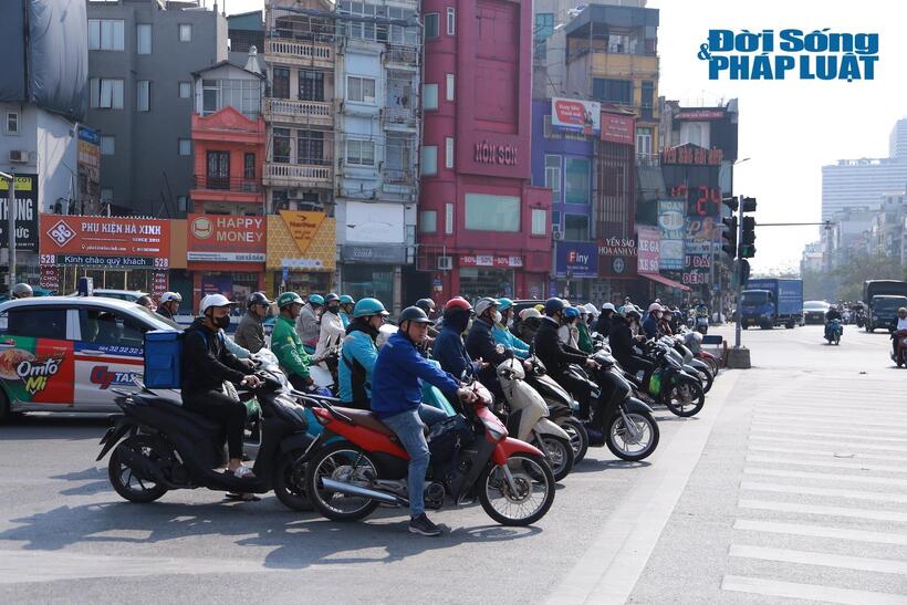 Người dân dừng trước vạch khi đèn tín hiệu chuyển sang màu đỏ tại khu vực nút giao ngã 7 Ô Chợ Dừa, Đống Đa, Hà Nội