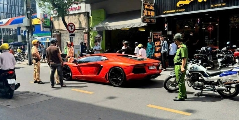 Tài xế xe Lamborghini cố thủ trên xe. (Ảnh: Công lý)
