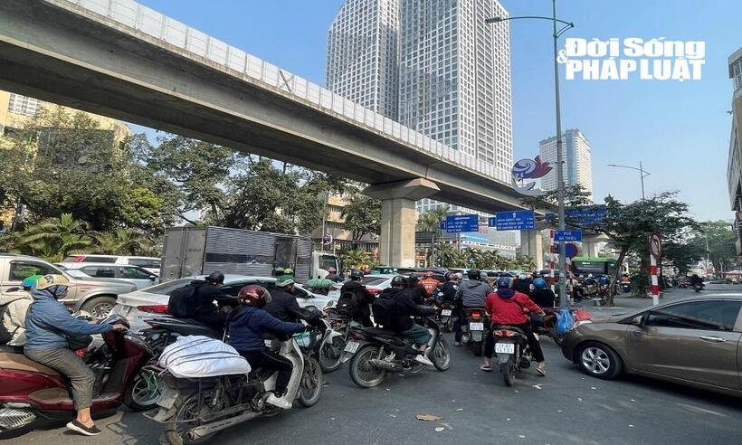 Các ô tô dàn thành hàng đi lấn sang làn xe máy khiến nhiều xe phải luồn lách qua các khe nhỏ để di chuyển.