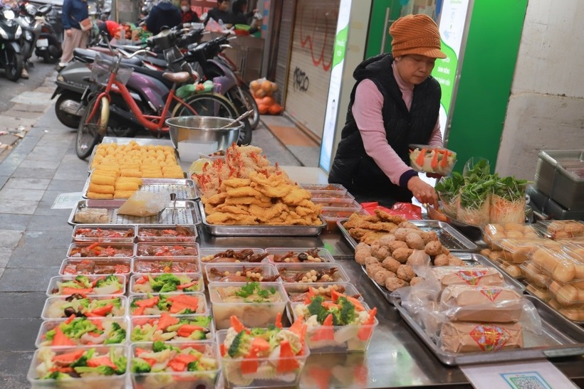 Ngoài xôi gấc, gà cánh tiên ngậm hoa hồng và các món canh truyền thống, tôm chiên xù, rau củ xào, thịt chiên cũng đông khách chờ mua.