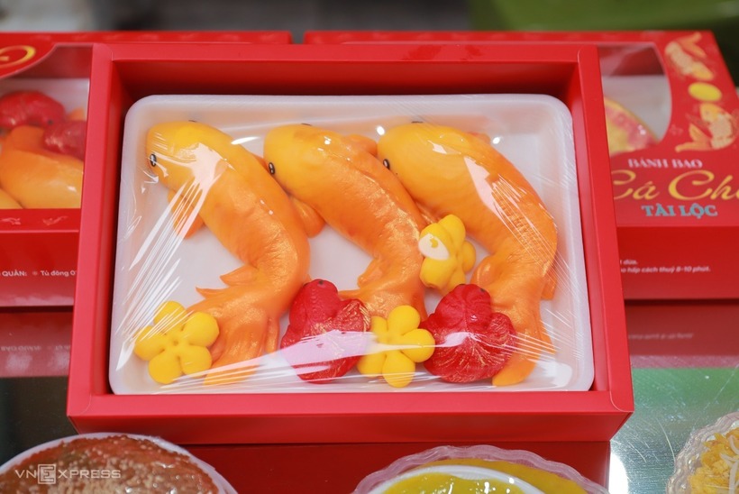 Một số cửa hàng còn bán xôi gấc và bánh bao tạo hình cá chép để phục vụ cho lễ cúng ông Táo. Giá bán từ 35.000 đồng với xôi gấc đến 150.000 đồng với hộp ba bánh bao cá chép.