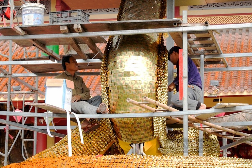 Ông Nguyễn Văn Dũng (bên trái, đơn vị thi công) cho biết trên Dân Việt: “Linh vật rắn này được 5 nghệ nhân thực hiện trong gần 1 tháng với tổng chi phí gần 100 triệu đồng. Khung rắn được làm bằng thép, da rắn được kết bởi nhiều tờ giấy vàng. Công đoạn làm da, vảy rắn được các nghệ nhân làm tỉ mỉ, sống động khiến tốn nhiều thời gian”.