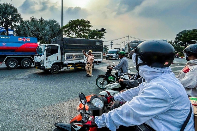 Lực lượng CSGT làm việc hết công suất, lượng người xe có giảm đôi chút nhưng lại tiếp tục ken cứng sau mỗi lần đèn tín hiệu bật lên.