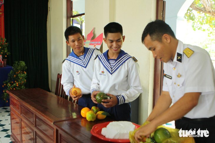Các chàng lính trẻ ở đảo Trường Sa nghe một sĩ quan giới thiệu những trái cây mà quê anh thường dùng cho mâm ngũ quả ngày Tết