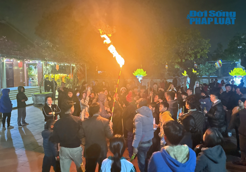 Ngọn đuốc ngay sau đó được trao cho một người khác đưa lửa ra sân chùa châm vào nơi chuẩn bị sẵn