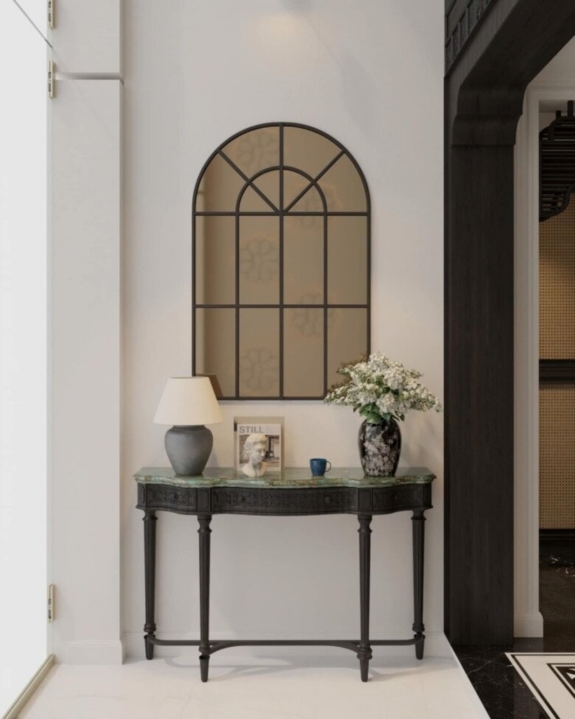 Một góc hành lang trong nhà được trang trí với bàn console đen họa tiết chạm khắc tinh xảo, mặt bàn làm từ đá tự nhiên tạo cảm giác sang trọng.