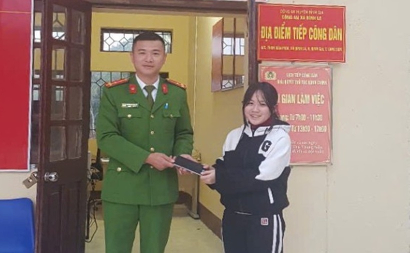 Cán bộ công an xã Bình La bàn giao điện thoại cho em Hứa Hoàng Trang. (Ảnh: Báo Lạng Sơn)