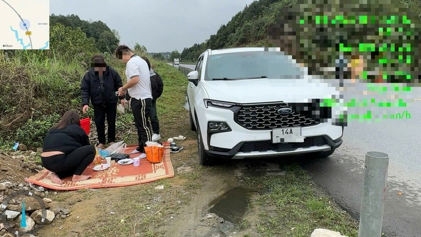 Hình ảnh gia đình anh T. dừng xe trên cao tốc, trải chiếu ăn cơm. Ảnh: Dân Trí