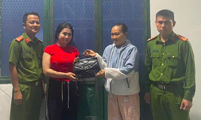 Bà Mãi (bên phải) trả lại túi xách cùng tài sản cho chị Nhiên. (Ảnh: Công an Phước Hậu)