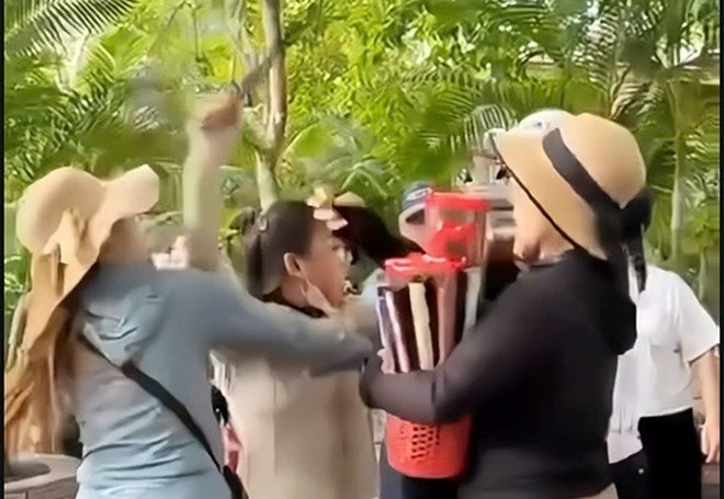 Hình ảnh nhóm người bán hàng rong xô xát với khách Trung Quốc ở TP Nha Trang. Ảnh: Lao Động