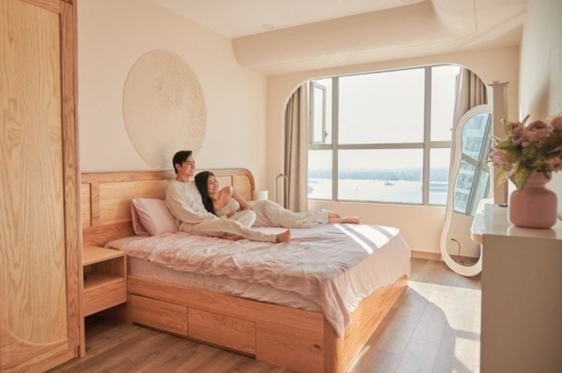 Phòng ngủ của vợ chồng Chúng Huyền Thanh – Jay Quân được bài trí đơn giản với chiếc giường ngủ gỗ, tủ quần áo và kệ sách. Từ cửa sổ của phòng ngủ, cặp đôi vẫn có thể nhìn thấy dòng sông Đồng Nai thơ mộng. Gam màu be nhẹ nhàng cũng tạo cảm giác thư giãn và ấm cúng cho căn phòng.