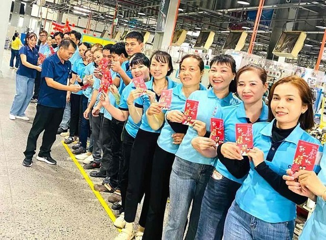 Công nhân Công ty Chang Shin Việt Nam TNHH (Đồng Nai) nhận lì xì trong ngày làm việc đầu tiên sau kỳ nghỉ Tết. (Ảnh: Người lao động)