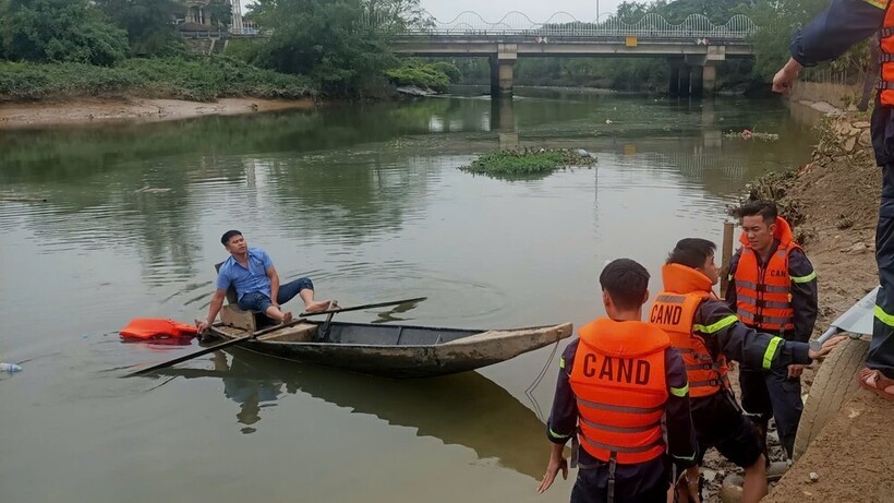 Lực lượng chức năng hỗ trợ tìm kiếm thi thể nam sinh. (Ảnh: Tiền phong)