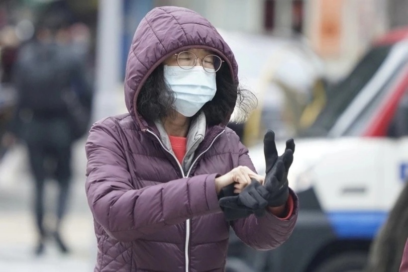 Người dân giữ ấm và hạn chế ra ngoài trời trong thời tiết giá lạnh. Ảnh: CNA.