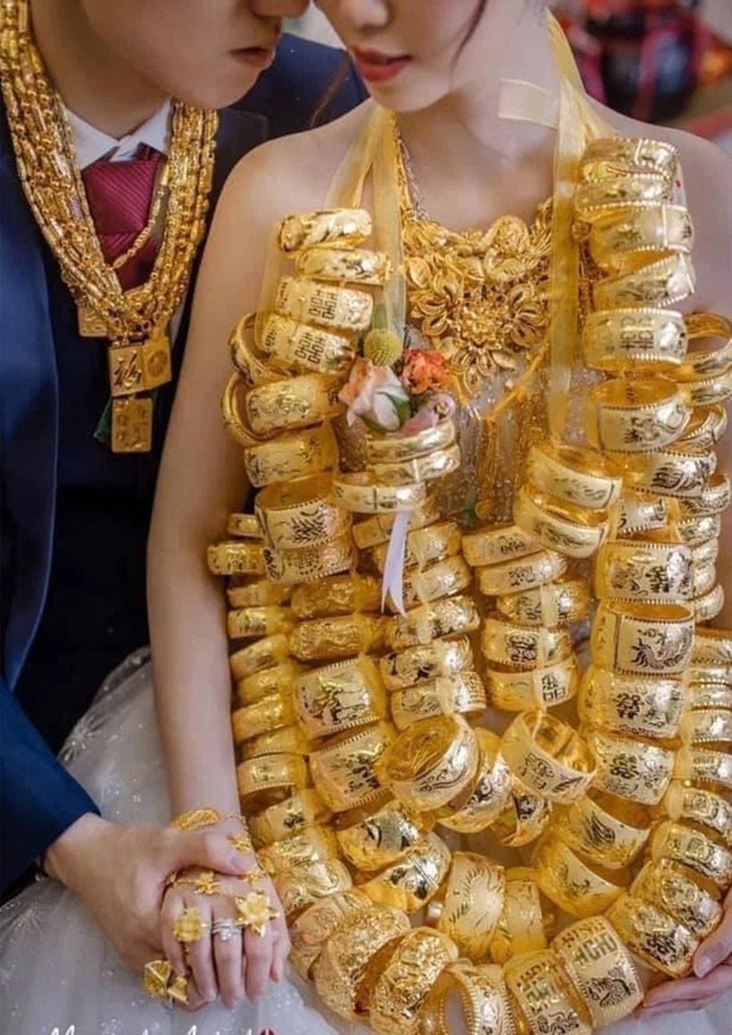 Khoảng 100 chiếc vòng vàng được xâu chuỗi lại đeo trên cổ gây khó khăn cho Yang Hanying trong việc di chuyển. Ảnh: Báo Dân trí.