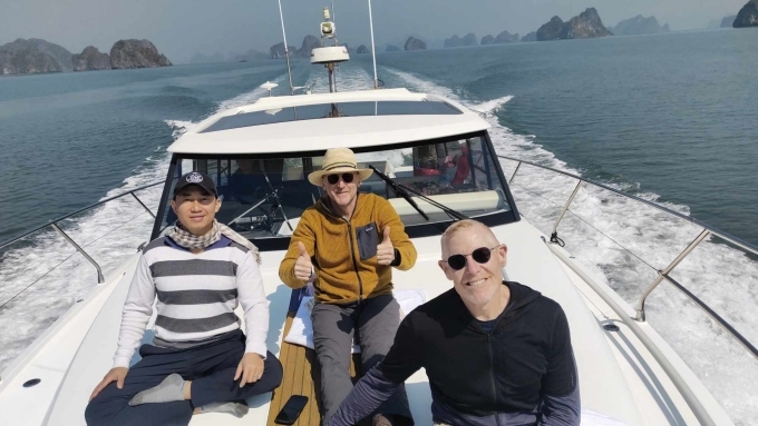 Ông Jeff Grinspoon (áo đen) và ông Jon Thomas Foley (áo vàng) đi thuyền trên vịnh Hạ Long trưa 11/2. (Ảnh: AAV)