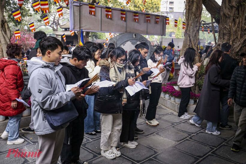 Nhiều bạn trẻ chuẩn bị văn khấn trước khi đến chùa Hà.